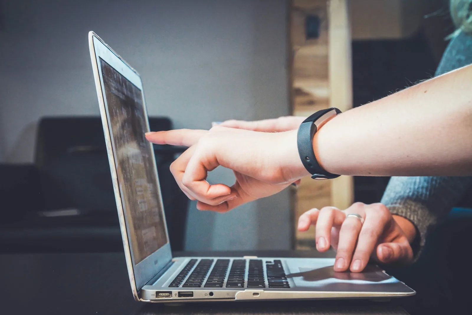 Persona che indica con il dito lo schermo di un laptop durante un controllo del sito